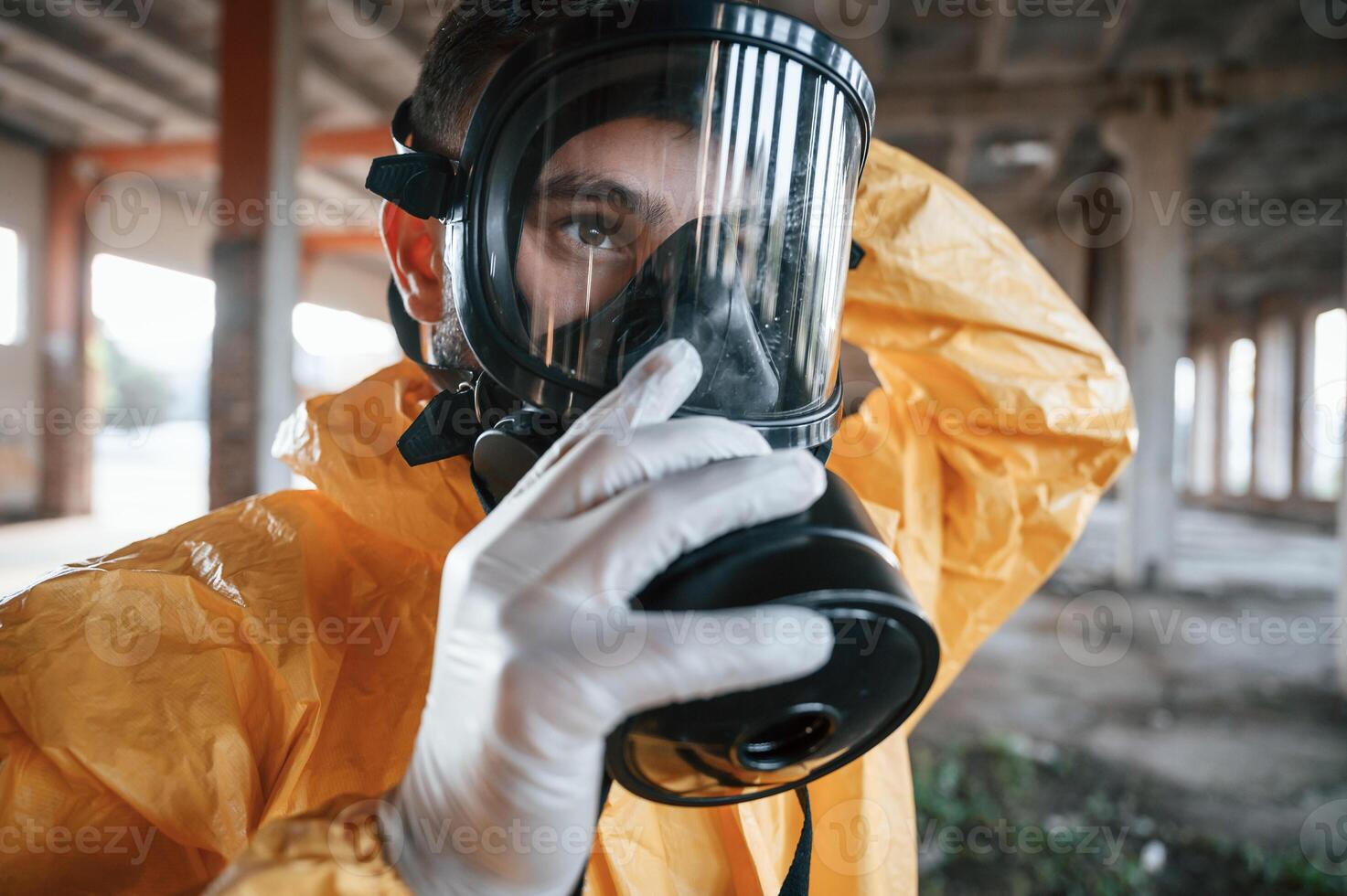 Wearing, the respirator. Man dressed in chemical protection suit in the ruins of the post apocalyptic building photo