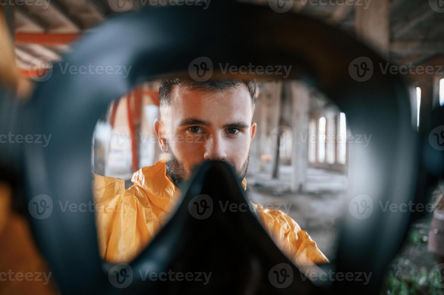 View through the respirator. Man dressed ,in chemical protection suit in the ruins of the post apocalyptic building photo
