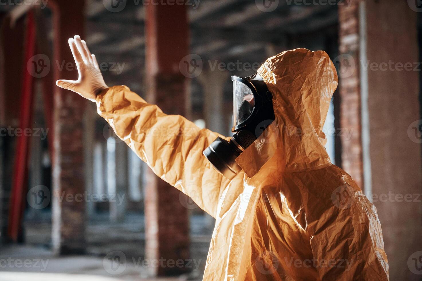 Nuclear explosion. Man dressed in,, chemical protection suit in the ruins of the post apocalyptic building photo