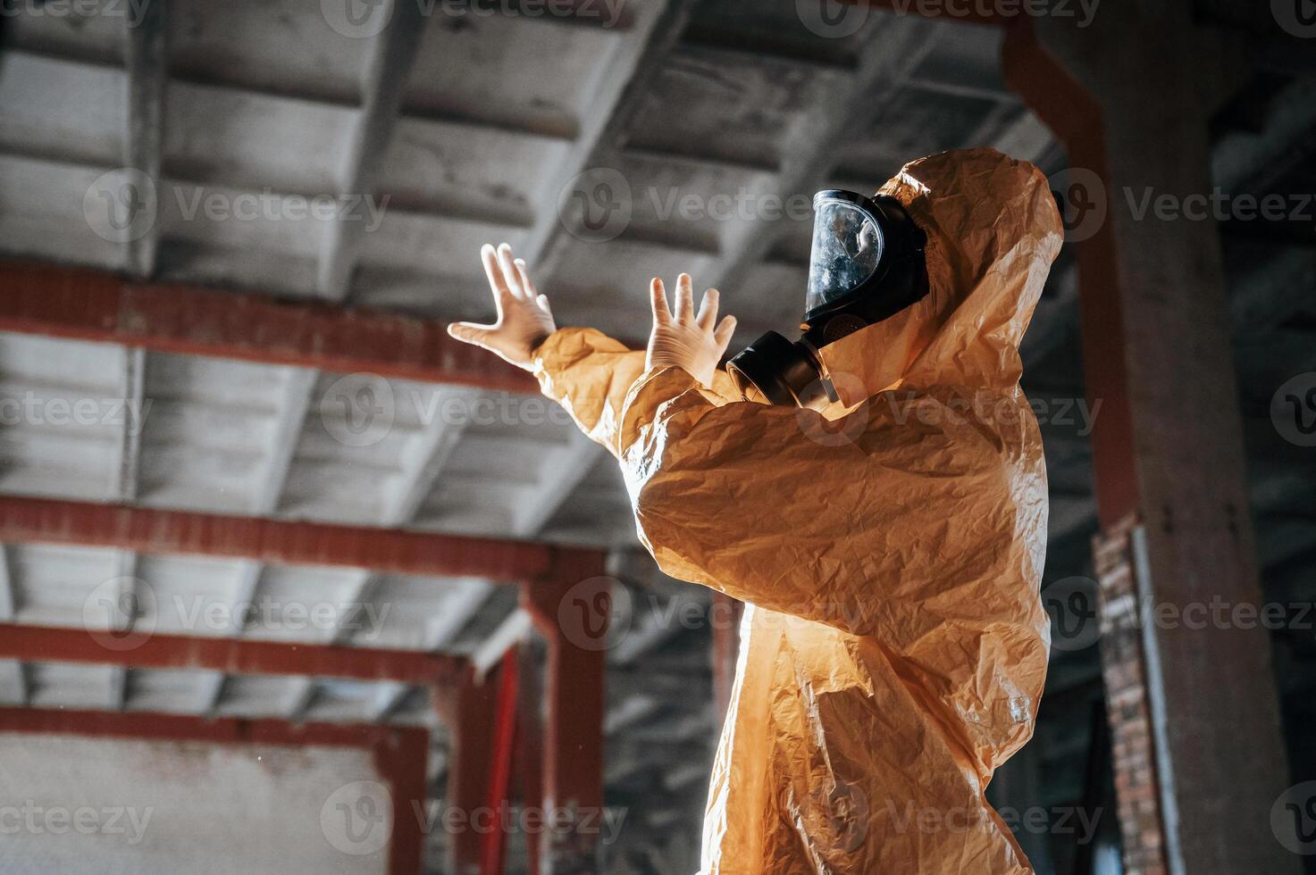 Nuclear explosion. .Man dressed ,in chemical protection suit in the ruins of the post apocalyptic building photo