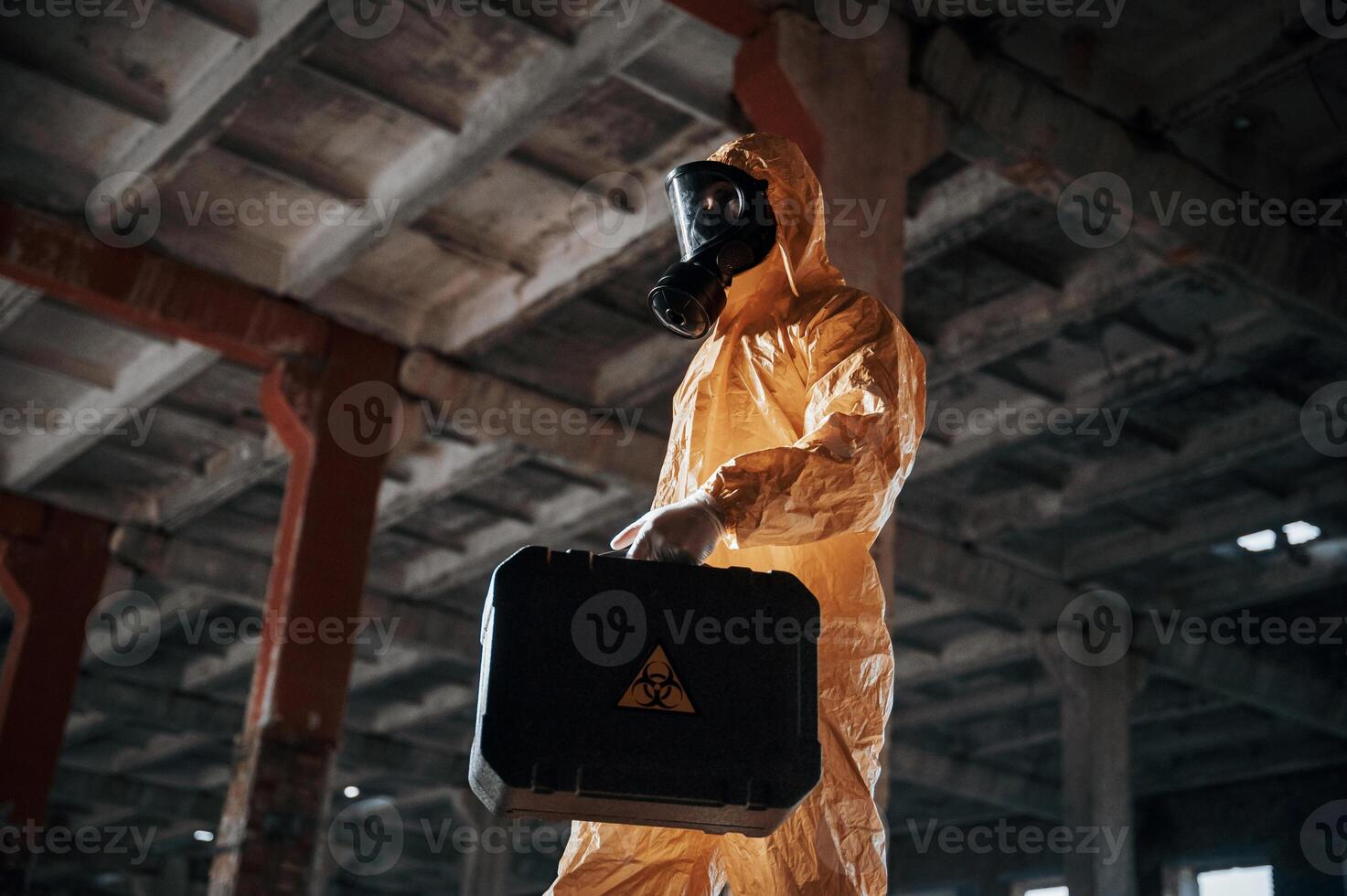 Bottom view.. Man dressed in chemical ,,protection suit in the ruins of the post apocalyptic building photo