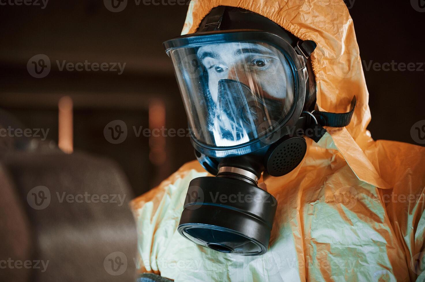 Frightened ,scientist is with radioactive materials. Man dressed in chemical protection suit in the ruins of the post apocalyptic building photo
