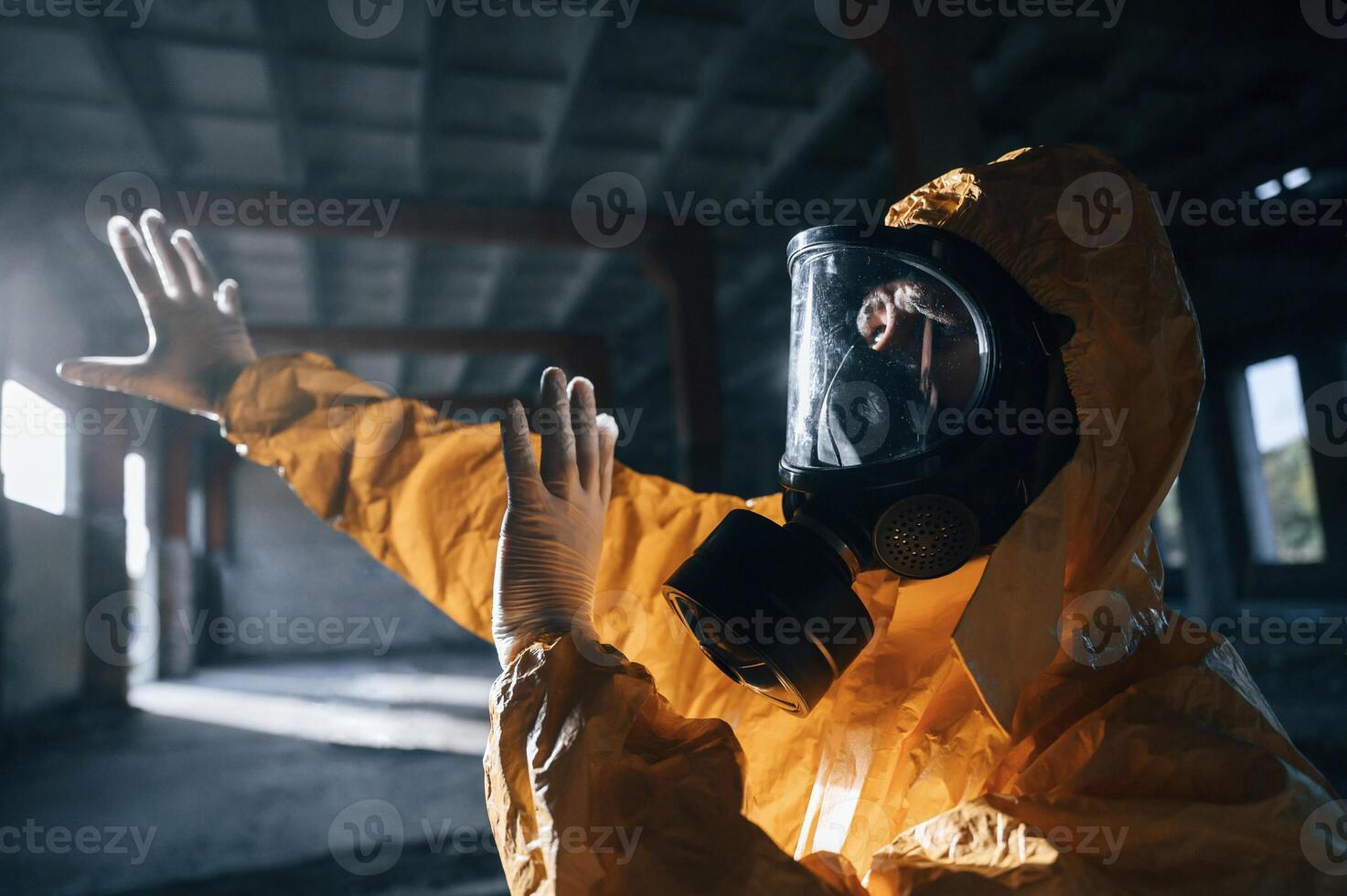 Light from nuclear explosion. Man, dressed ,in chemical protection suit in the ruins of the post apocalyptic building photo