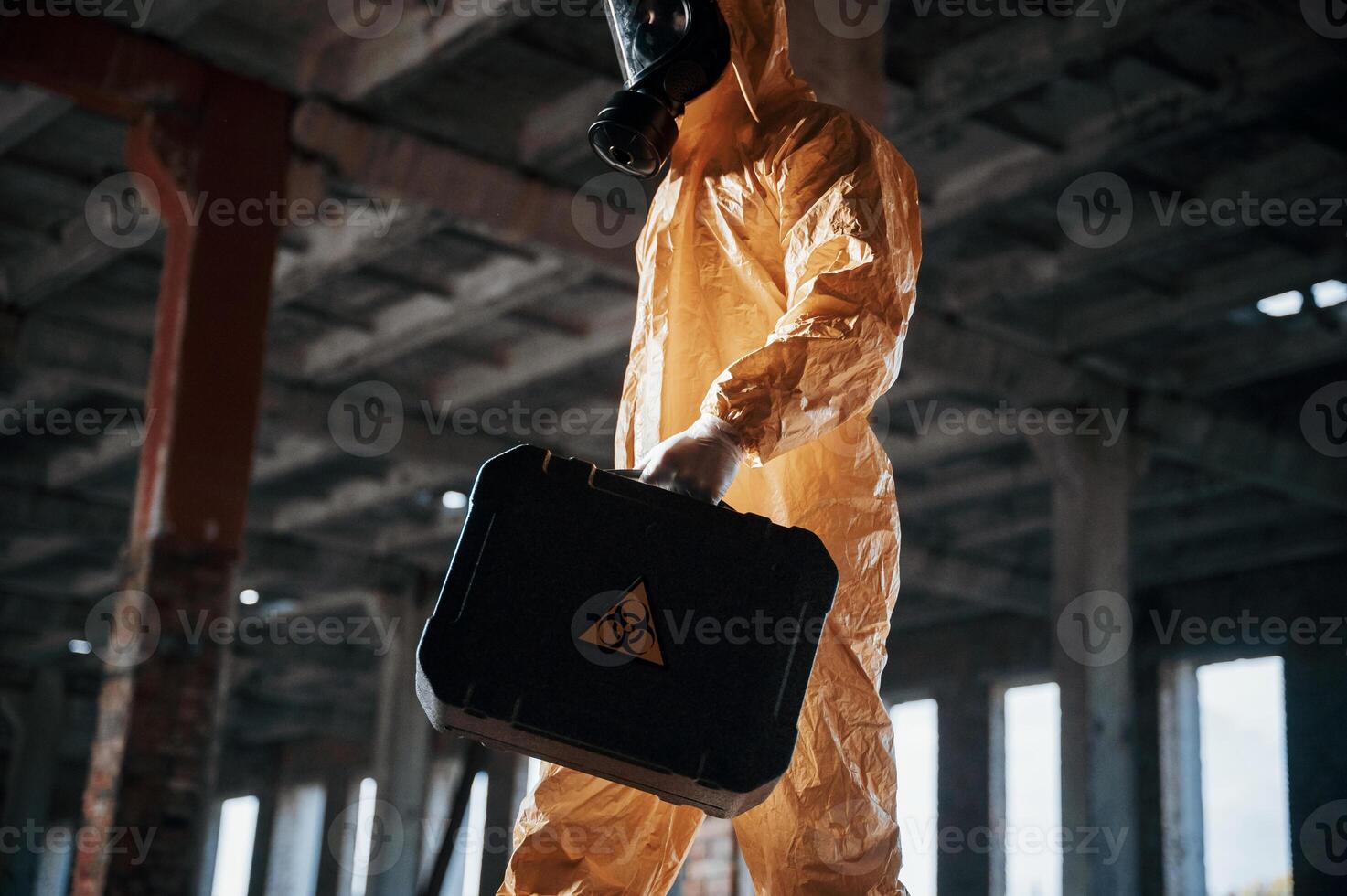 Bottom view. Man dressed in chemical protection ,suit in the ruins of the post apocalyptic building photo
