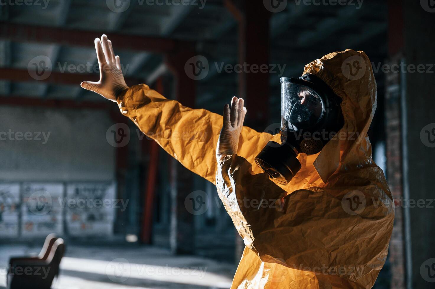 Nuclear explosion.. Man dressed in chemical protection suit in the ruins of the post apocalyptic building photo