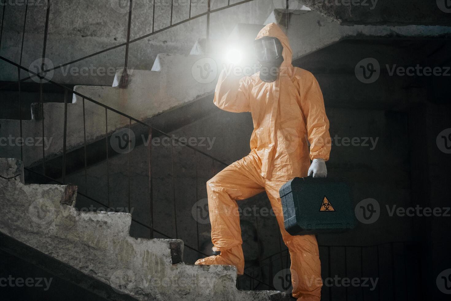 Man dressed in chemical protection suit in the ruins, of the post apocalyptic building photo