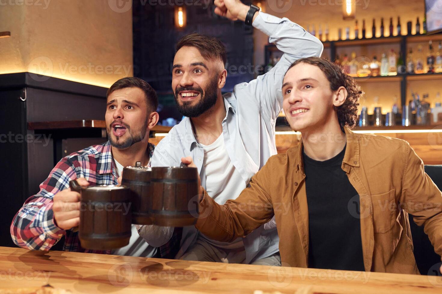 Soccer fans ,watching match. Three friends are in the bar drinking beer and having a good time photo