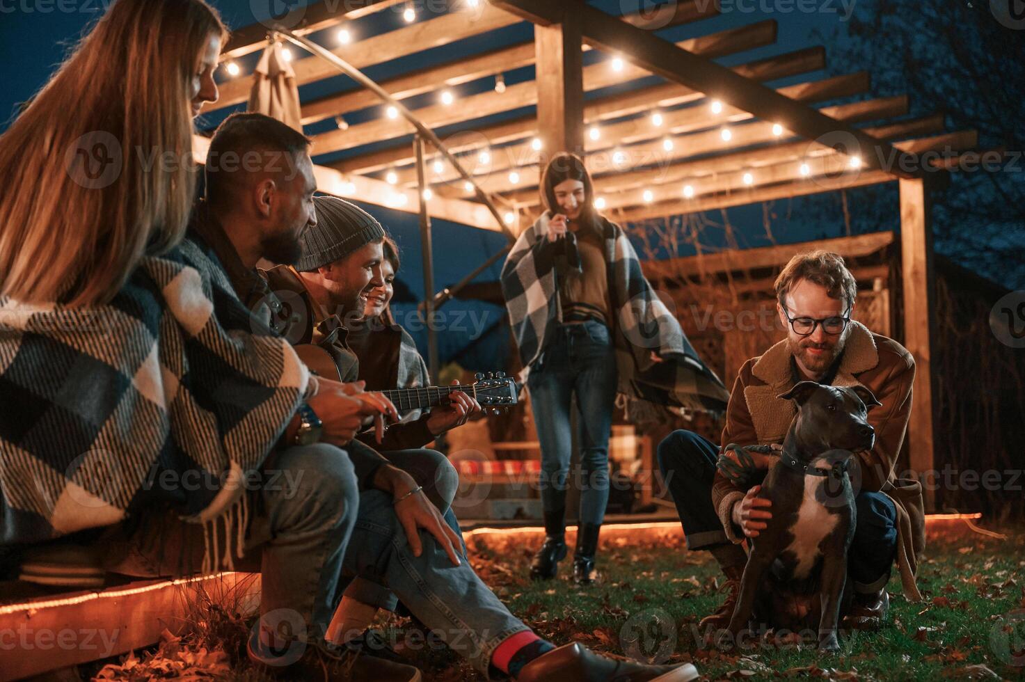 Evening time. Group ,of people is spending time together on the backyard photo