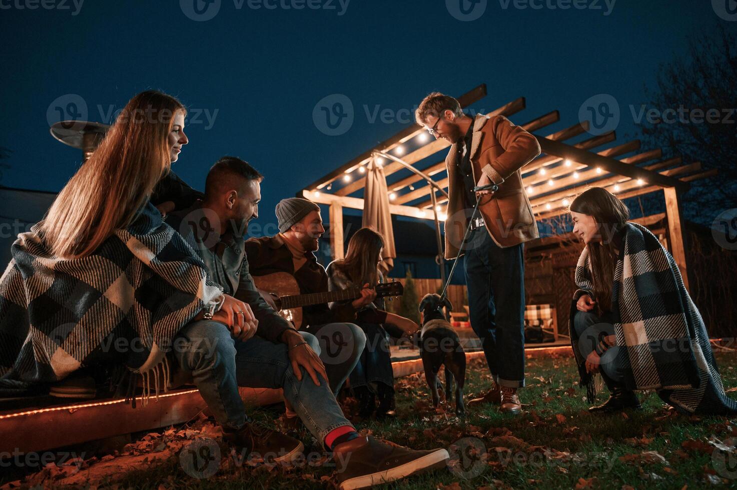 Evening time.. Group of people is spending time together on the backyard photo