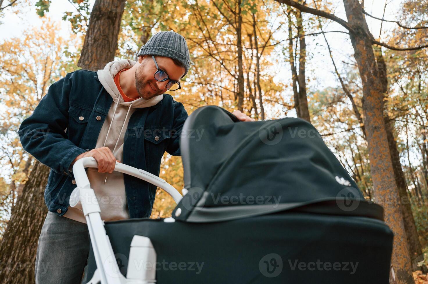 Looking ,inside the pram. Man is having a walk in the autumn park photo