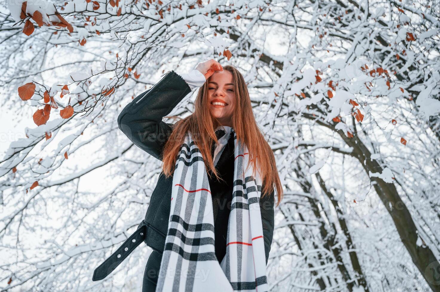 View from below. .Beautiful young woman is outdoors in the winter forest photo