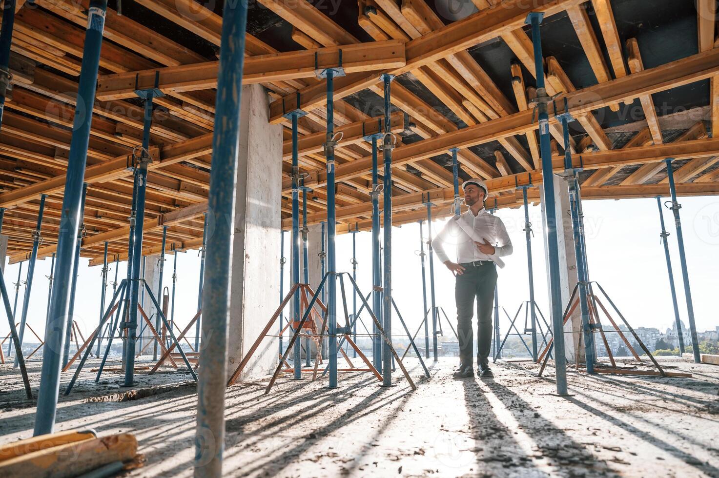 Beautiful sunlight.. Walking ,with plan in hands. Man is working on the construction site at daytime photo