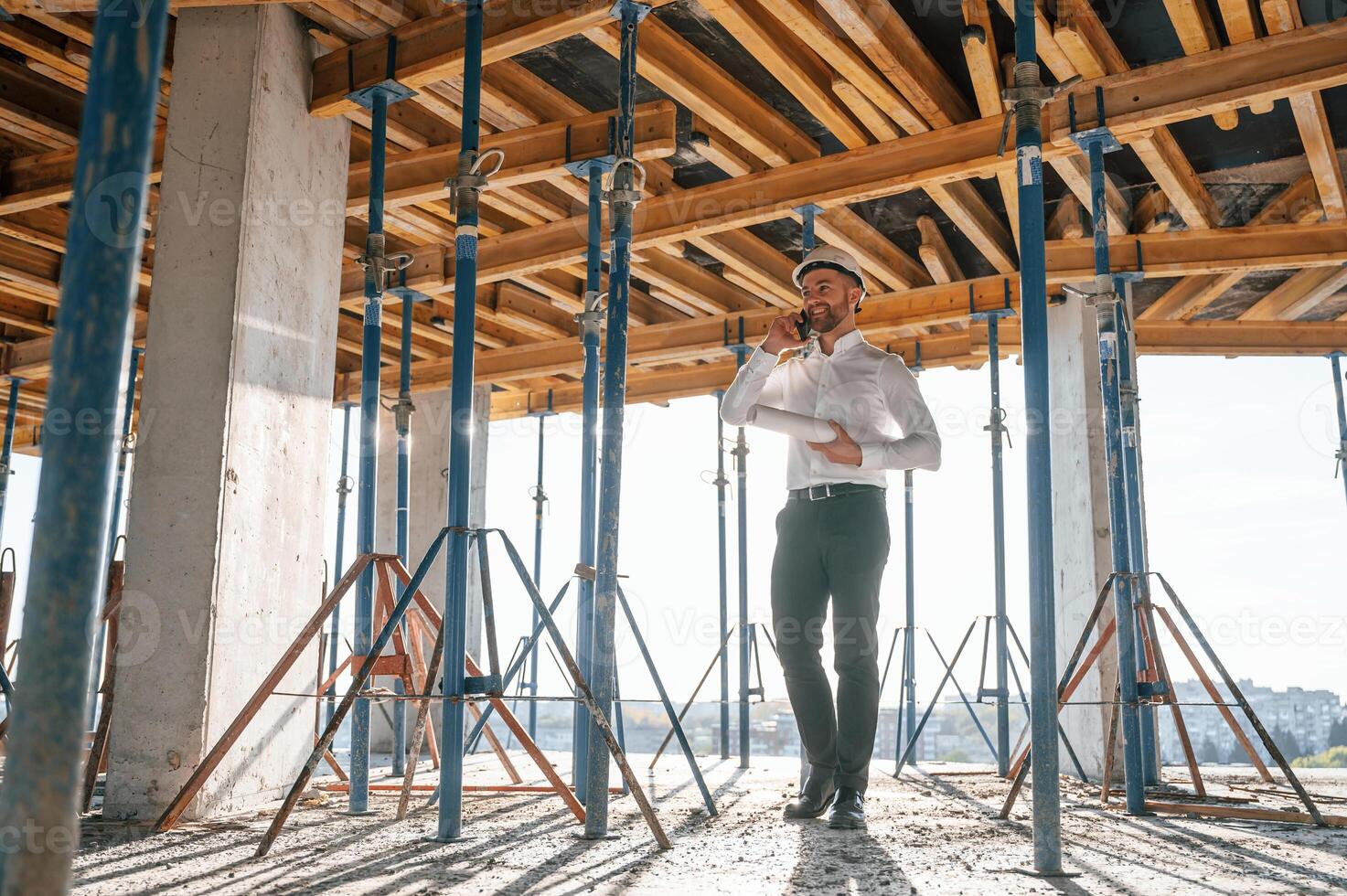Beautiful ,sunlight. Walking ,with plan ,in hands. Man is working on the construction site at daytime photo