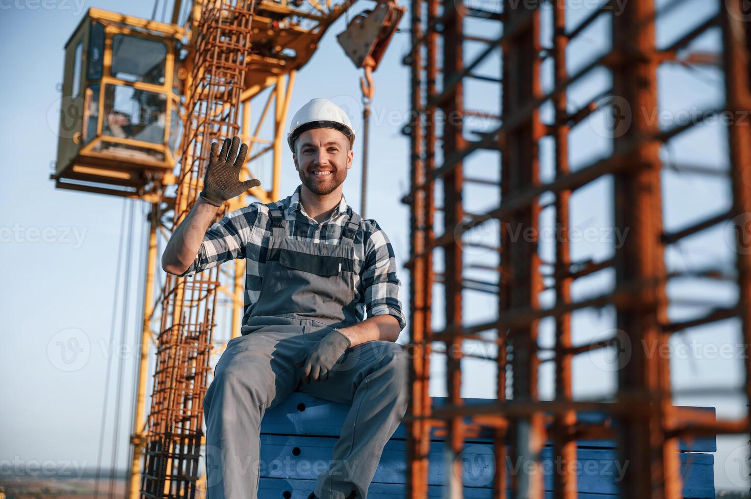 Sitting and smiling. Man is working on the construction site at daytime photo