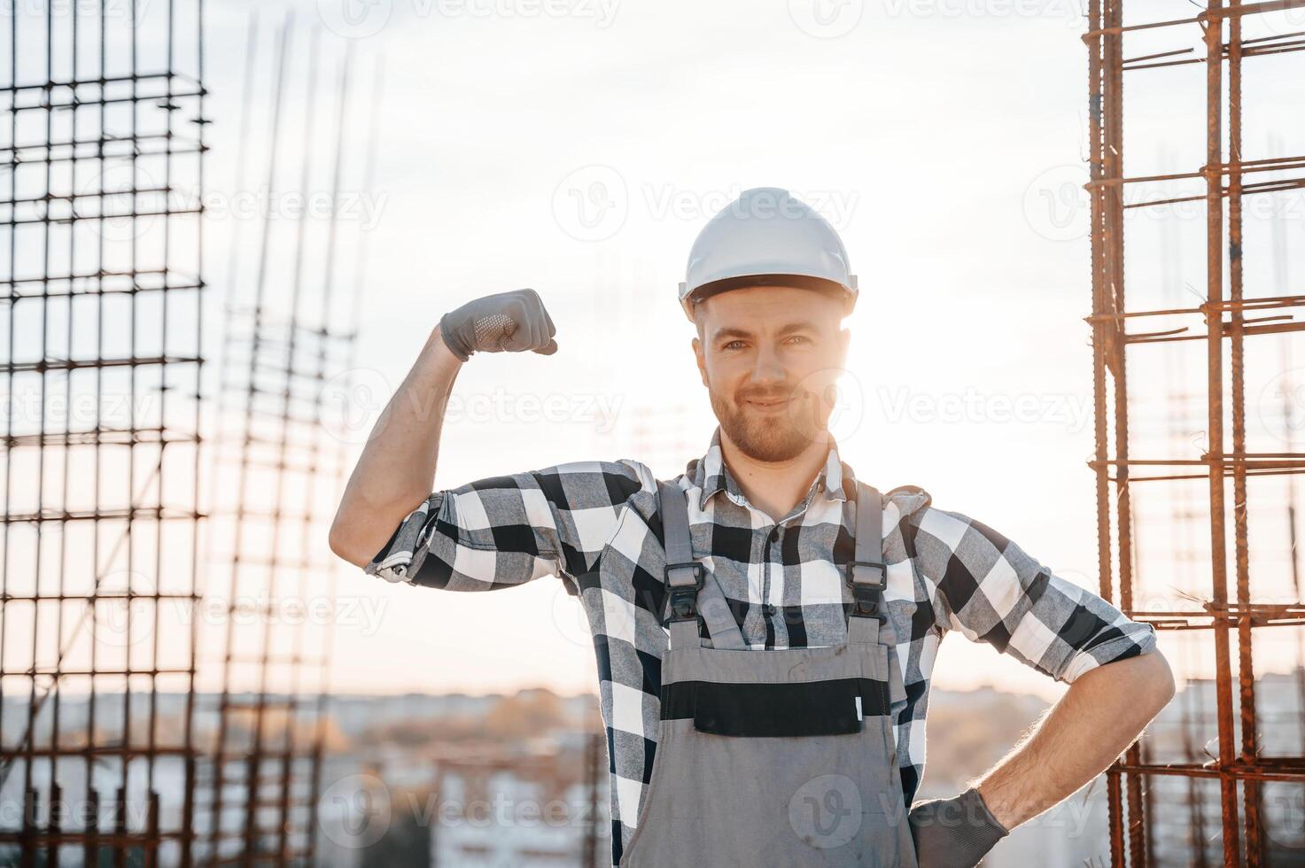 Showing ,biceps. Conception of succes. Man is working on the construction site at daytime photo