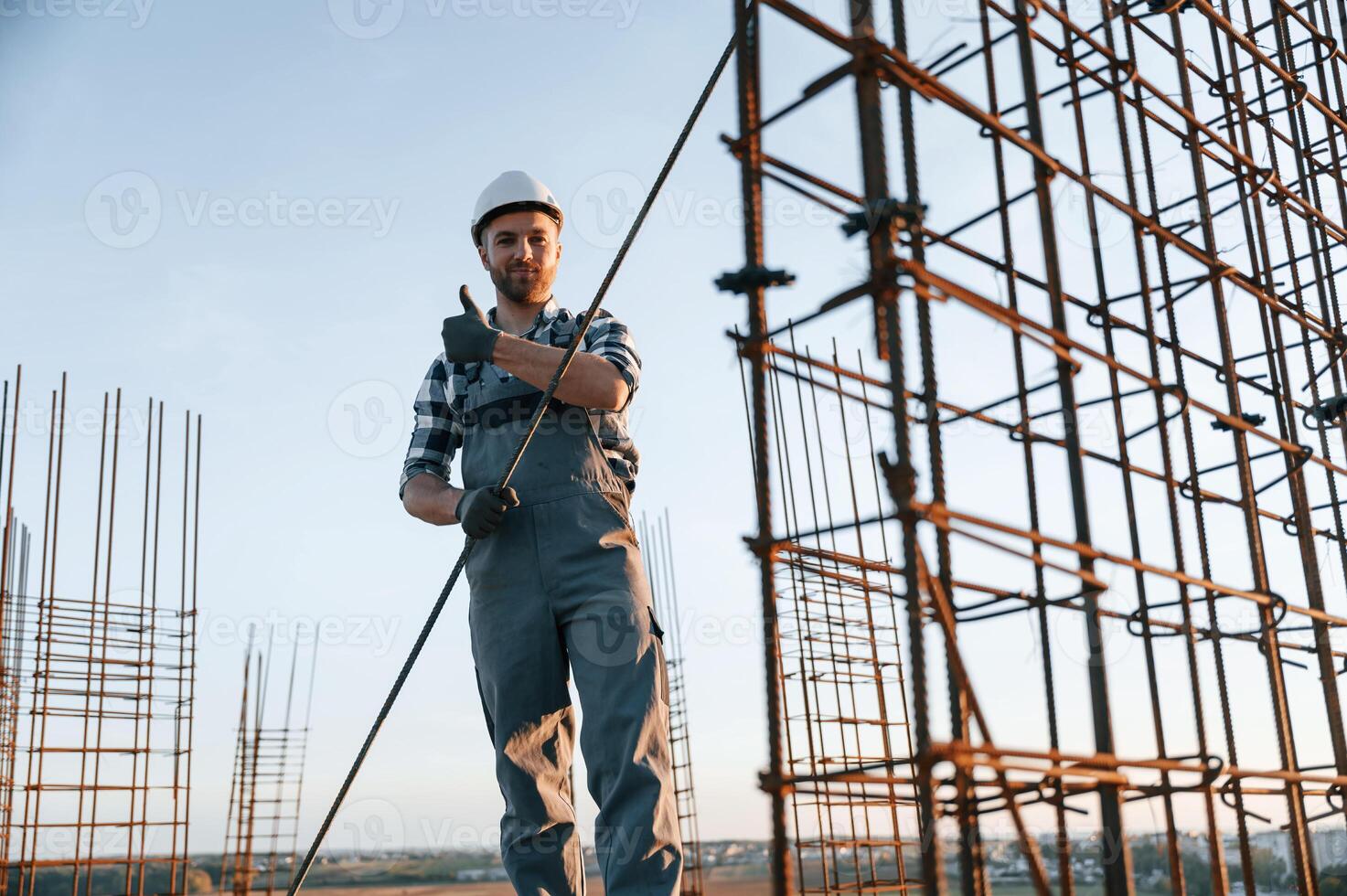 Holding ,metal ,object in hands. Man is working on the construction site at daytime photo