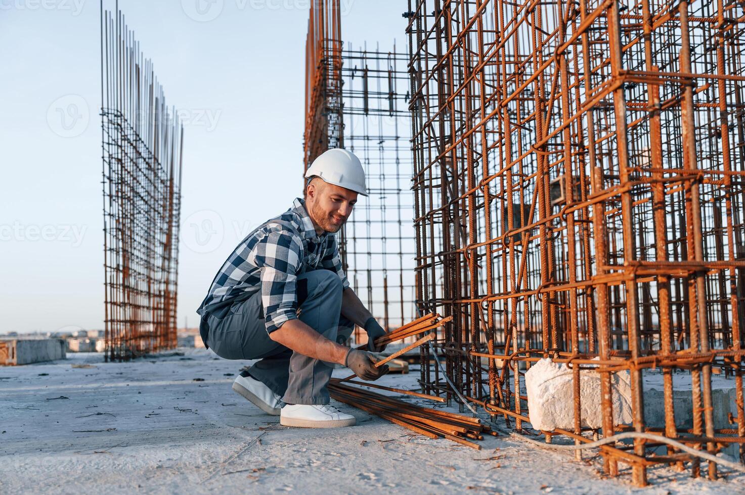 With ,rusty metal objects. Man ,is working on the construction site at daytime photo
