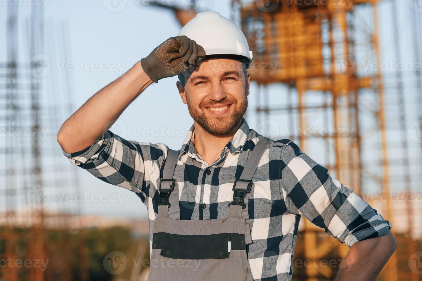Handsome man is working on the construction site at daytime photo