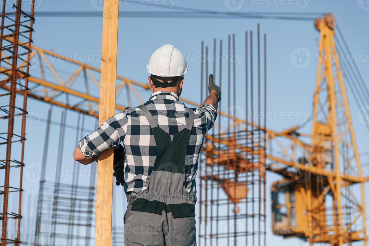 Giving ,orders to crane operator. Man is working on the construction site at daytime photo