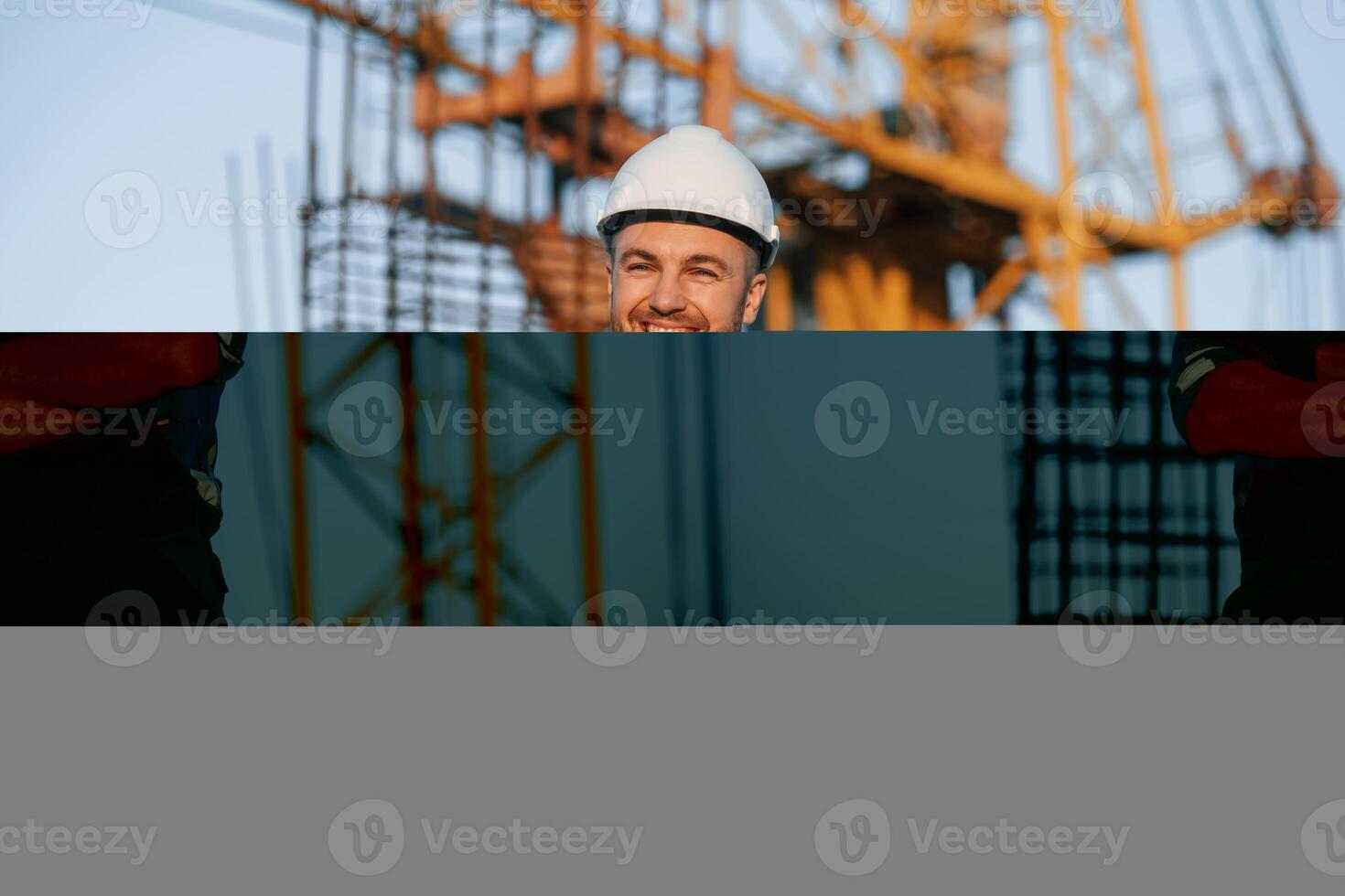 Happy worker is standing on the construction ,site at ,daytime photo