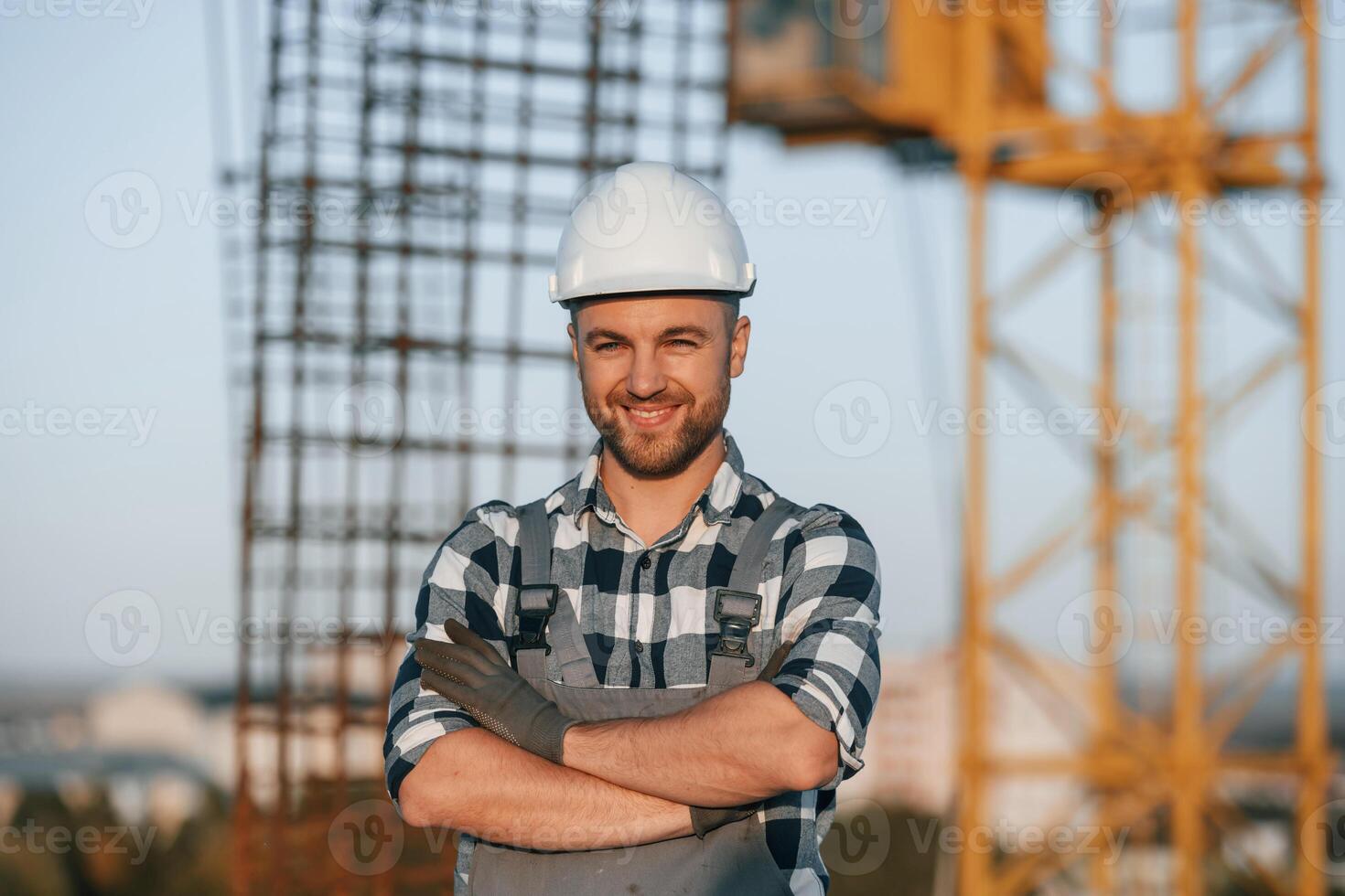 Handsome man is working on the construction site at, daytime photo
