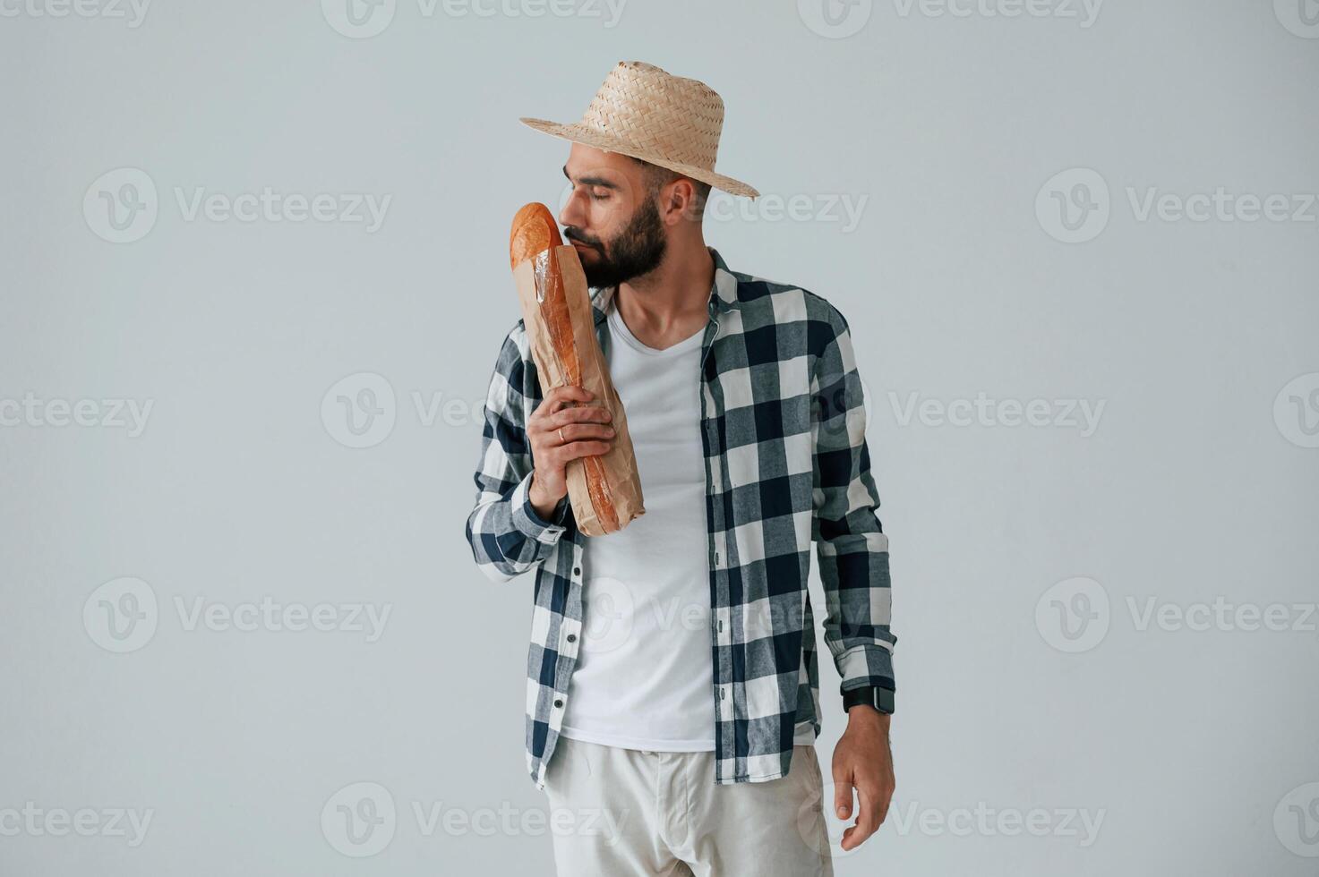Tourist, in hat holding baguette. Handsome man is in the studio against white background photo