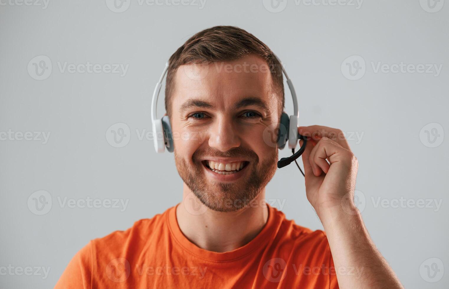 Conception, of call center. In headset. Handsome man is in the studio against white background photo