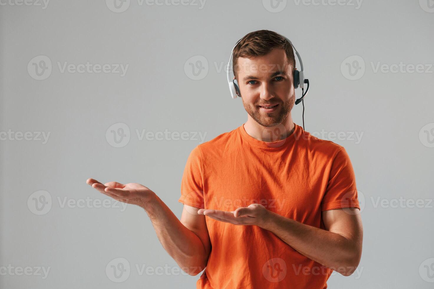 Conception of call center. ,In headset. Handsome man is in the studio against white background photo