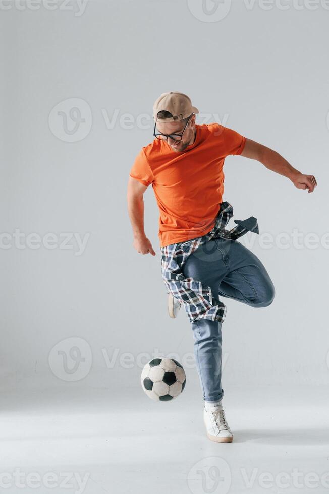 Doing tricks, playing with ,soccer ball. Handsome man is in the studio against white background photo