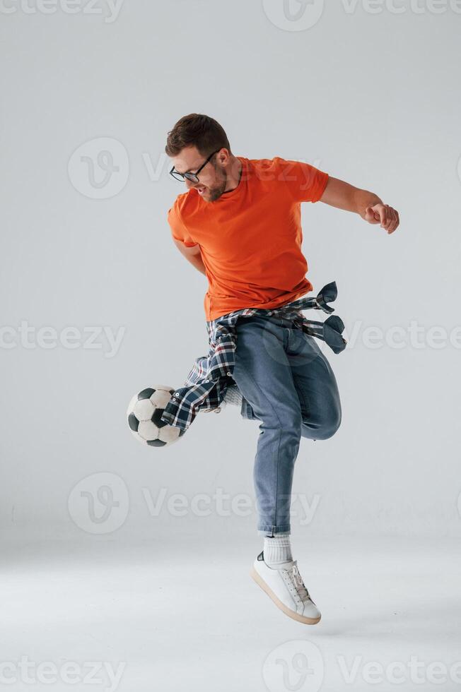 Playing with soccer ball. Handsome man is in the studio against white background photo
