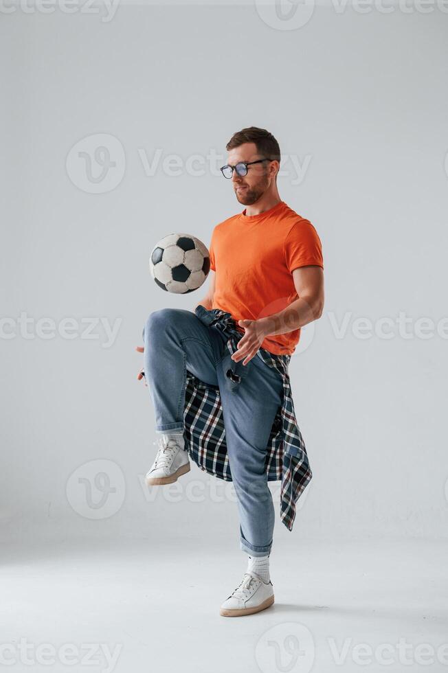 Playing ,,with soccer ball. Handsome man is in the studio against white background photo
