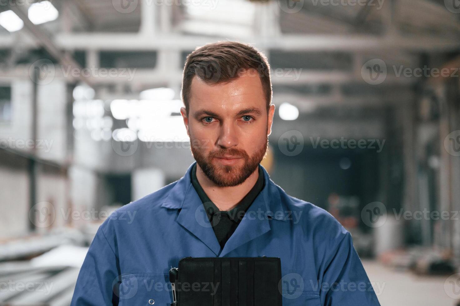 Portrait of factory ,worker that is in blue uniform indoors photo