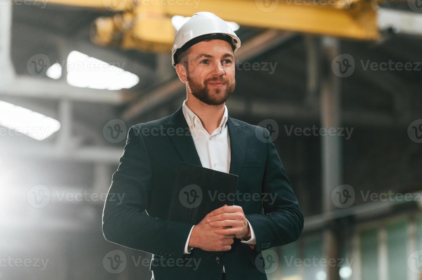Portrait of manager that ,is in black formal wear at the factory photo