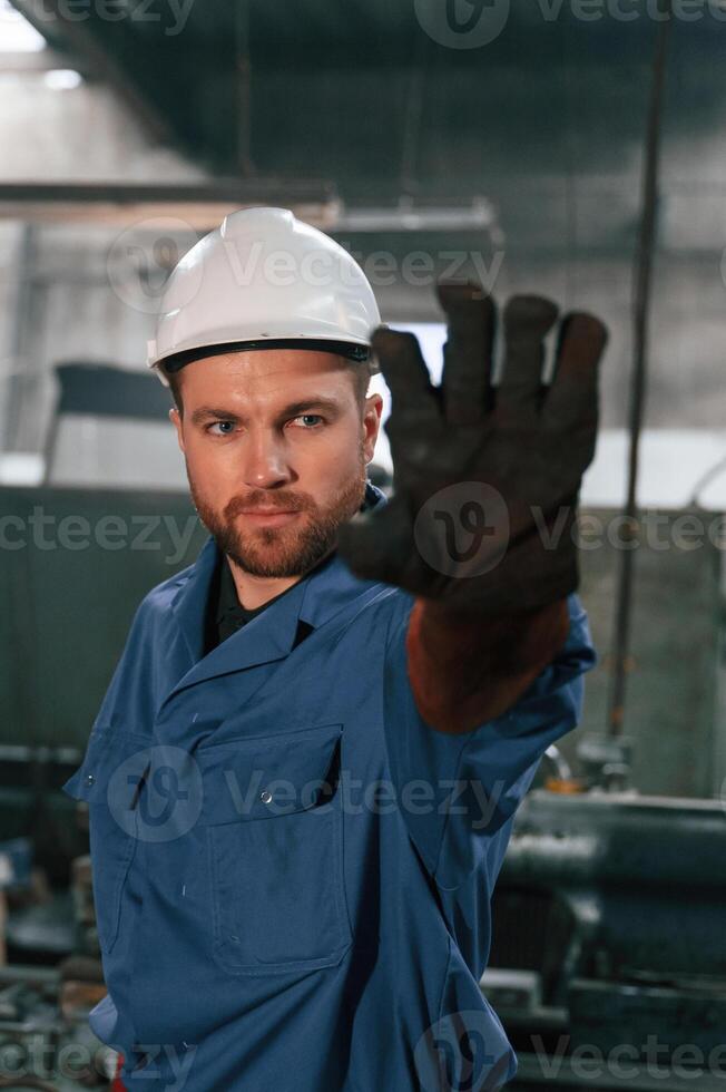 Factory,, worker in blue uniform is indoors photo