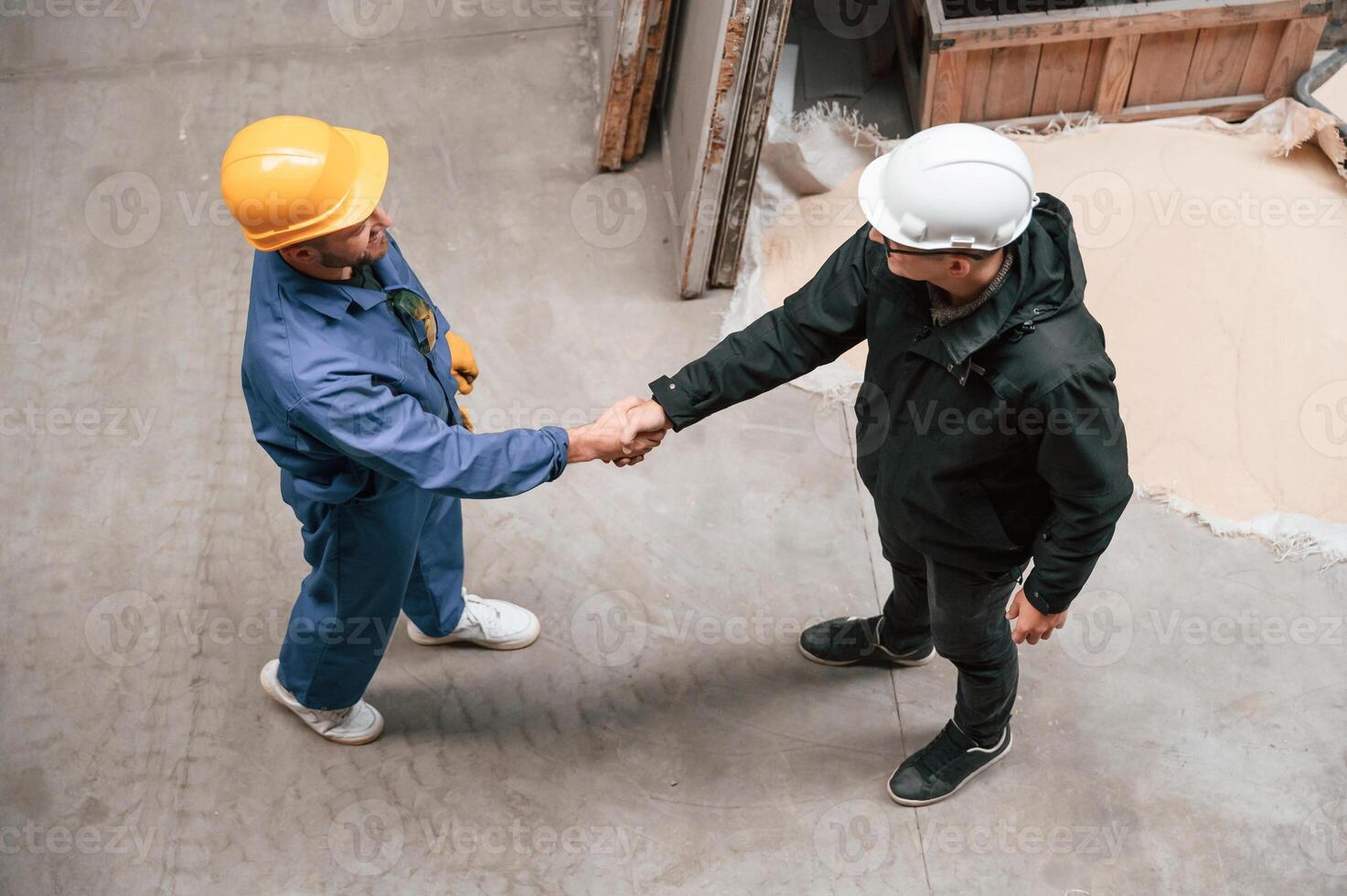 Two, industrial workers are doing handshake. Top view. Successful agreement photo