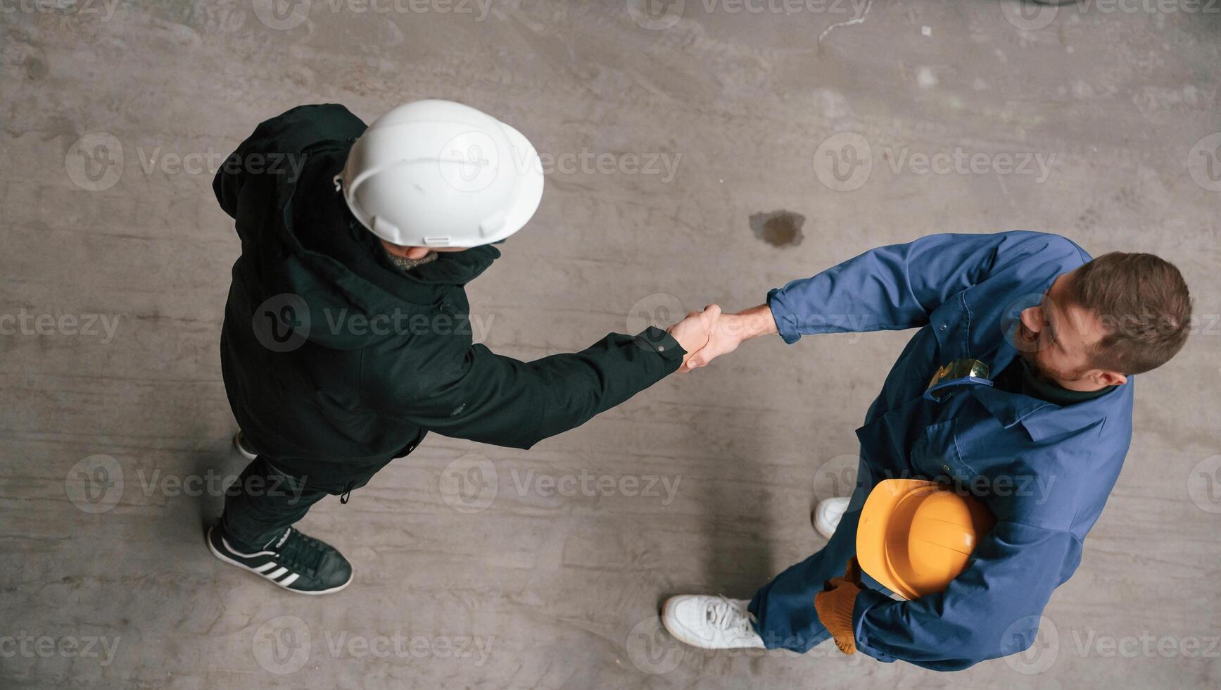 Two industrial ,workers are doing handshake. Top view. Successful agreement photo