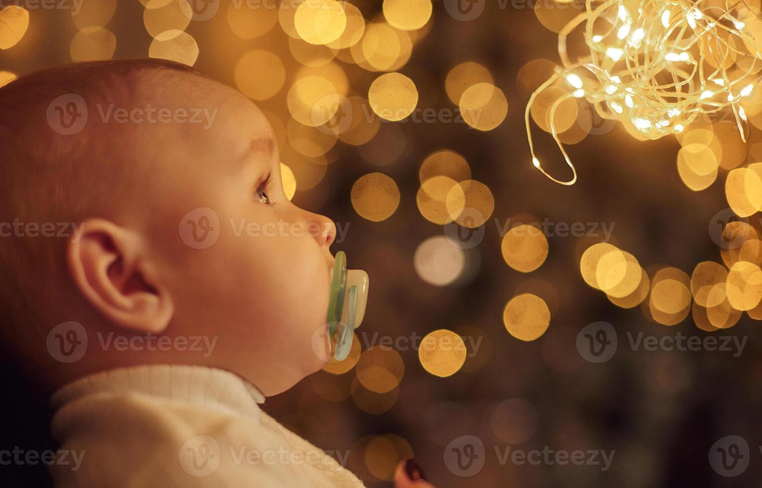Side view. .With ,garlands. Cute little baby is at home. New year decorations. Conception of holidays photo
