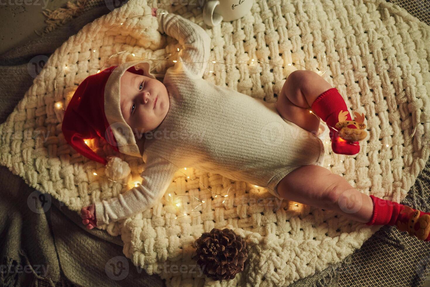Little baby is lying ,down on the ground. In Christmas clothes. Conception of new year photo