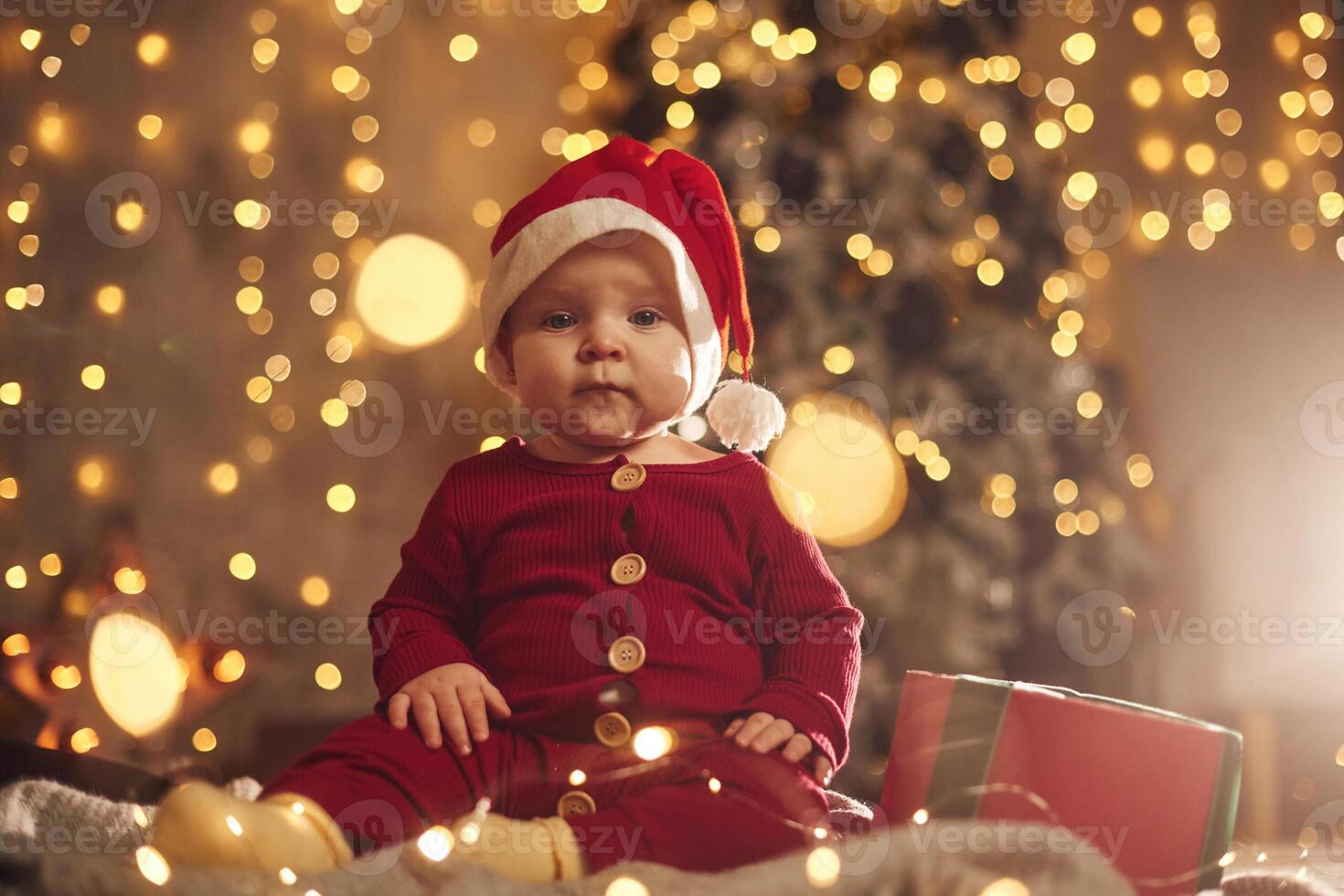In Santa hat. Cute little ,baby is at home. New year decorations. Conception of holidays photo