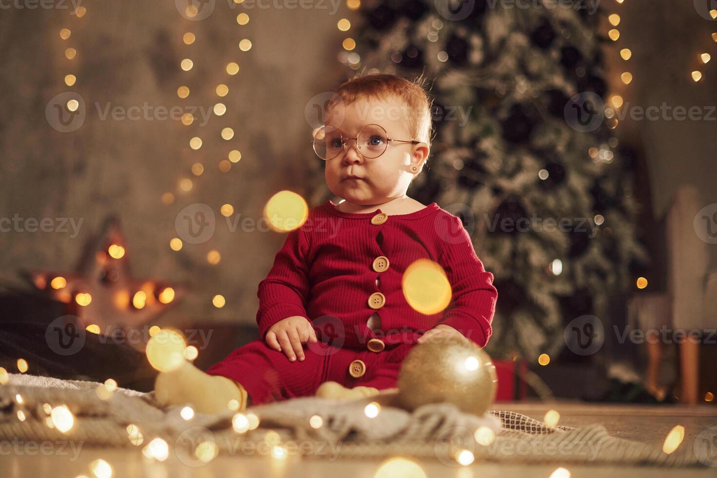 In glasses. Cute, little baby is at home. New year decorations. Conception of holidays photo