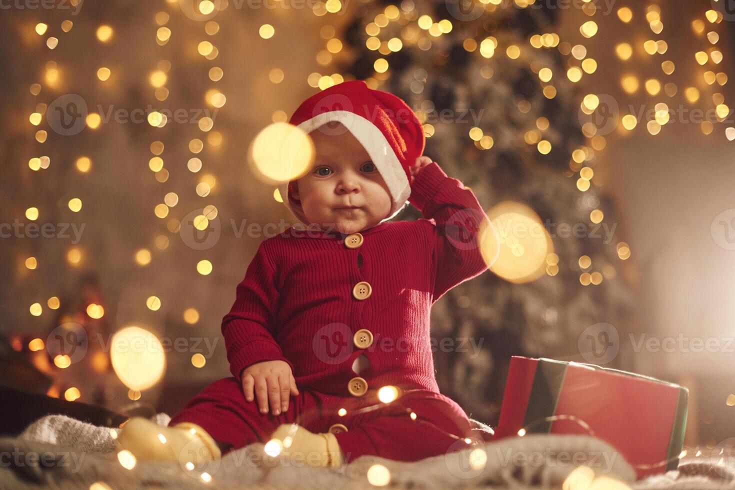 In, Santa hat.. Cute little baby is at home. New year decorations. Conception of holidays photo