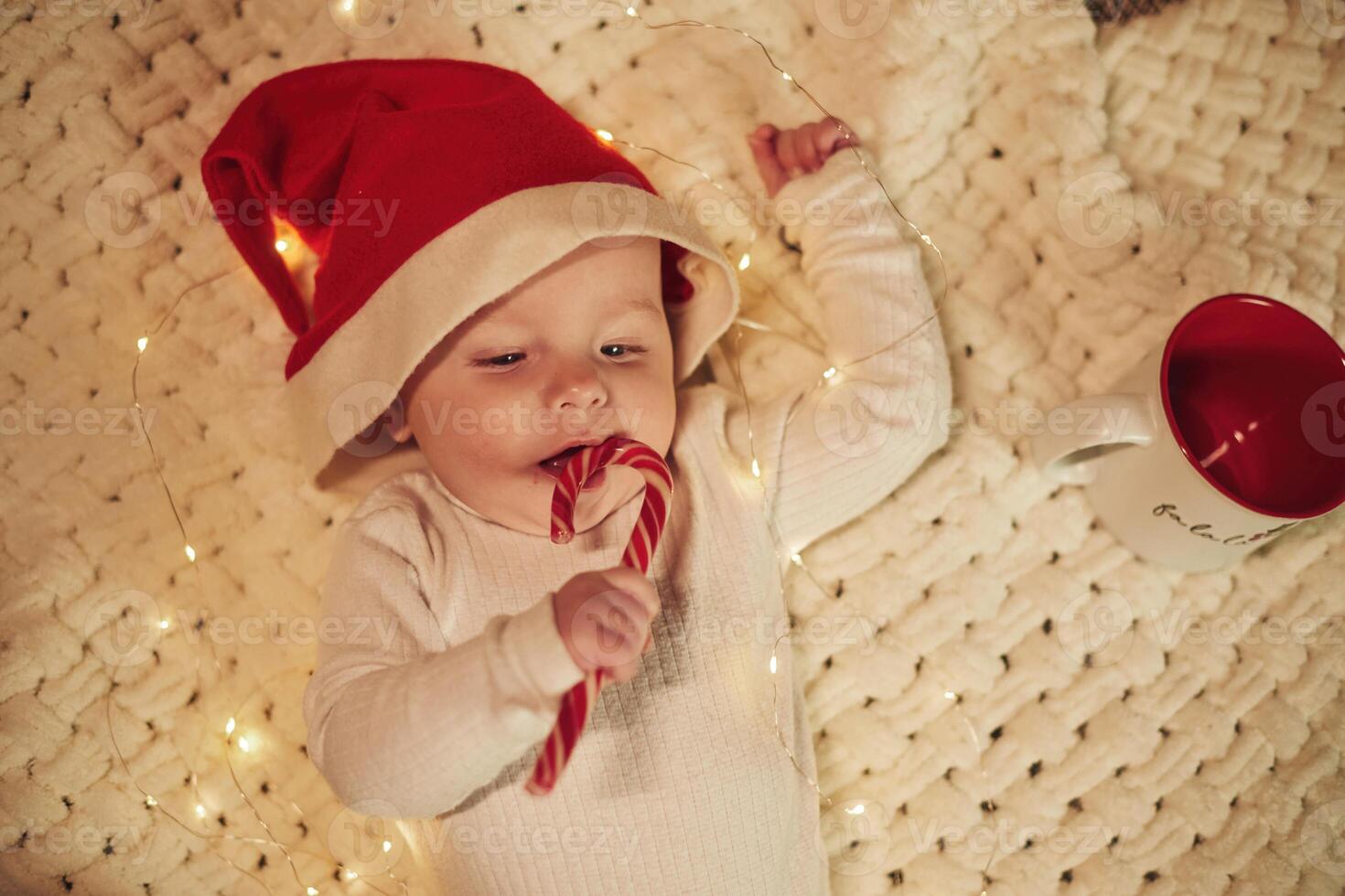 Little ,baby is lying down on the ground. In Christmas clothes. Conception of new year photo