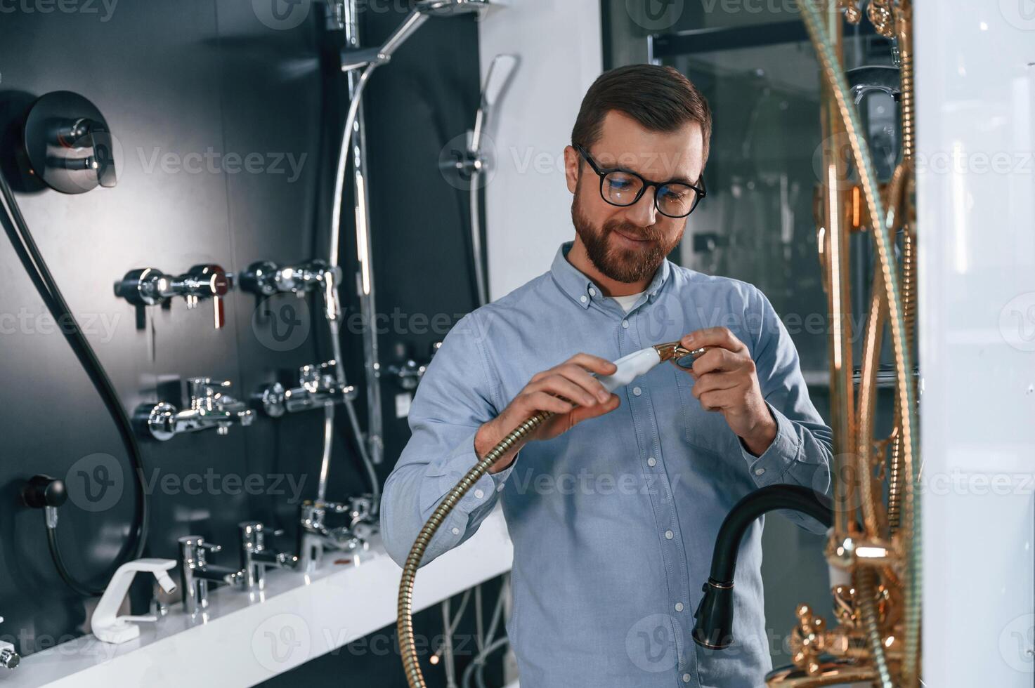 Selects, a shower faucet. Man chooses a products in a sanitary ware store photo