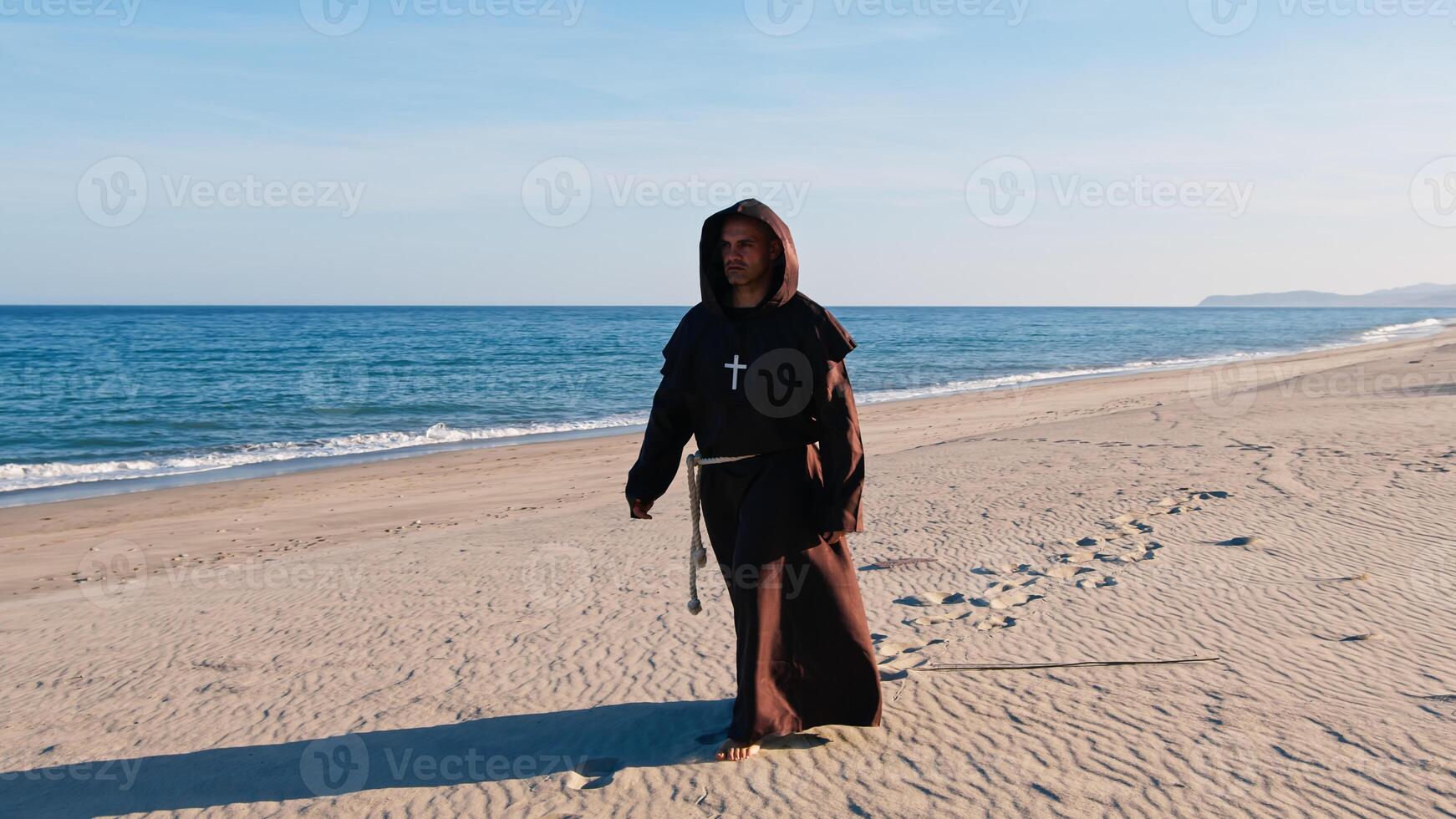 Christian Priest Walking Barefoot On The sandy beach photo