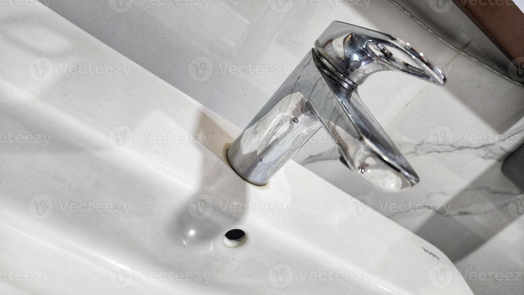 a white sink with a faucet and a mirror photo