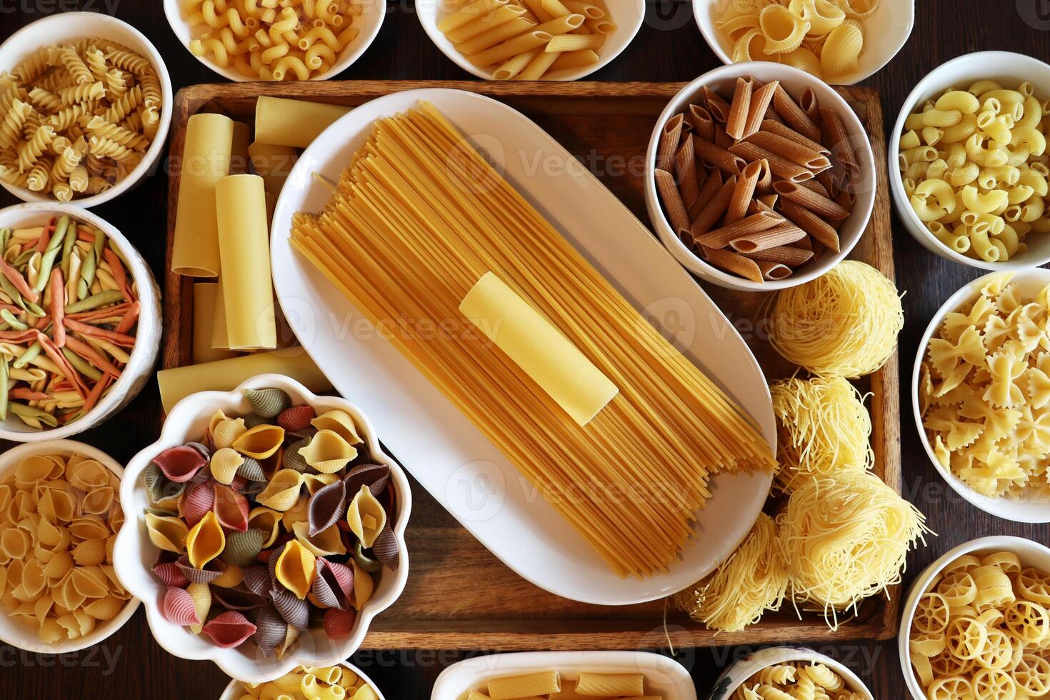 Pasta. Various kinds of uncooked pasta and noodles , top view . Italian food culinary concept. Collection of different raw pasta on cooking table photo