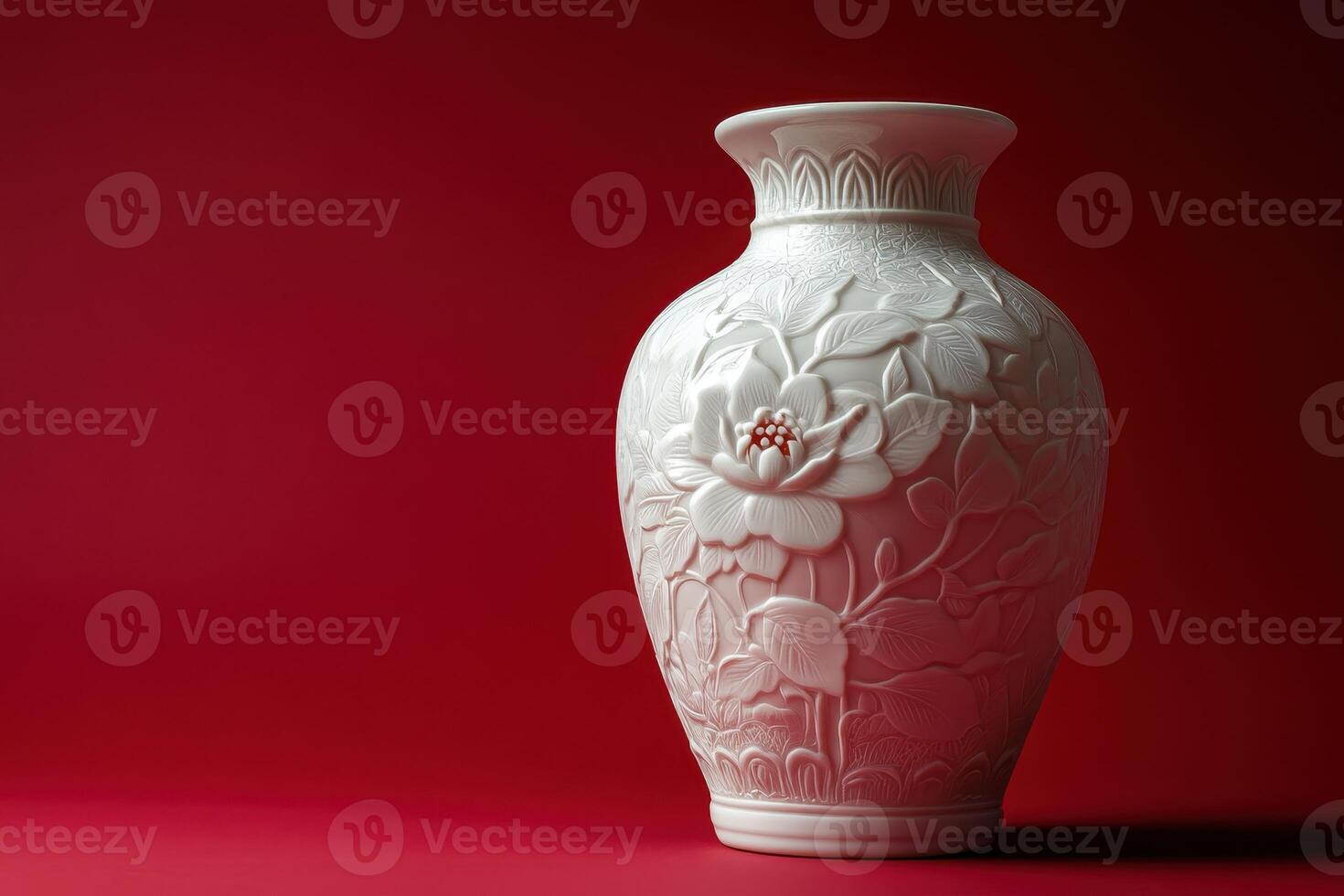 White Porcelain Vase with Floral Design on Red Background photo