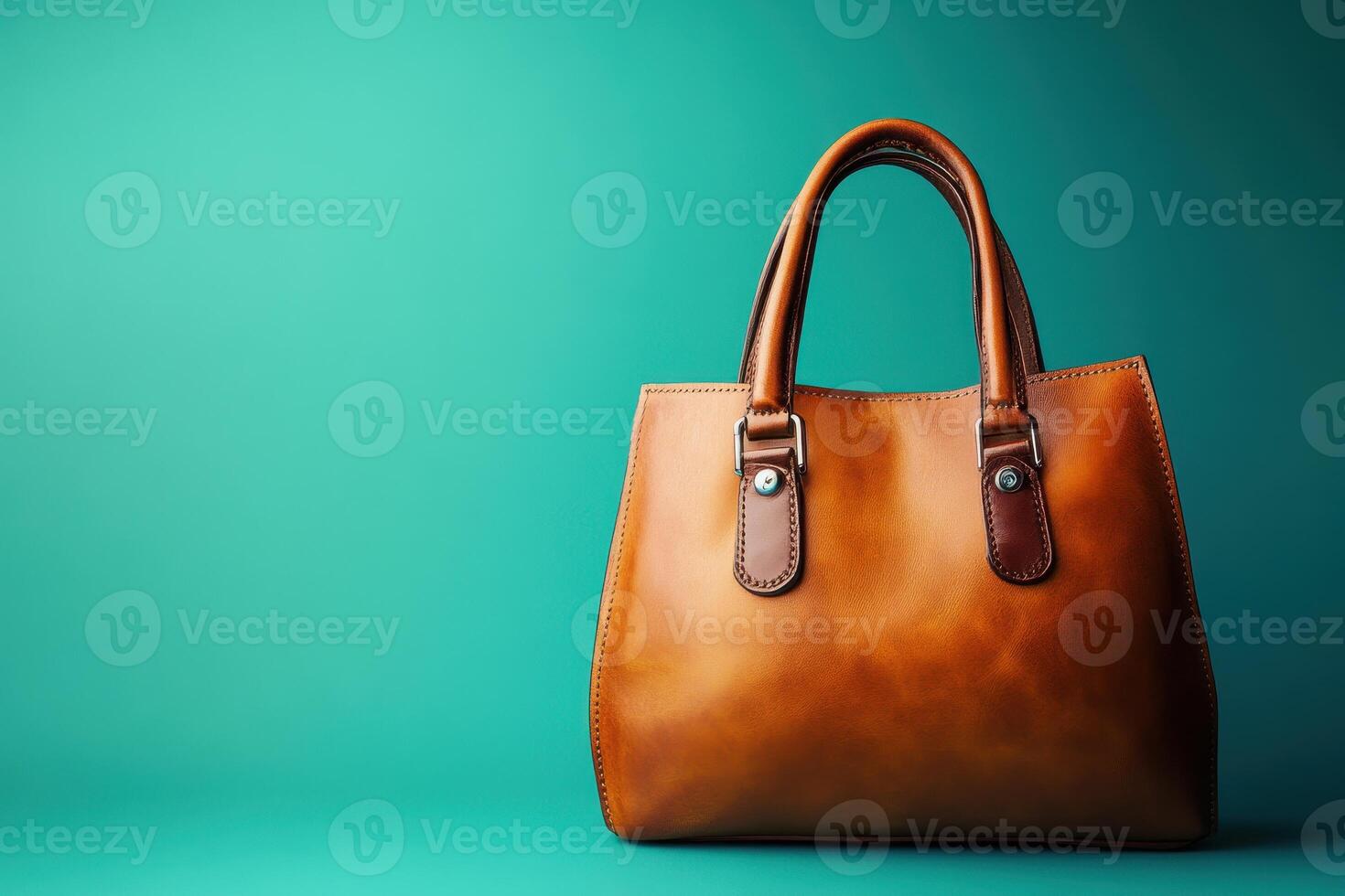 Brown leather handbag on teal background photo