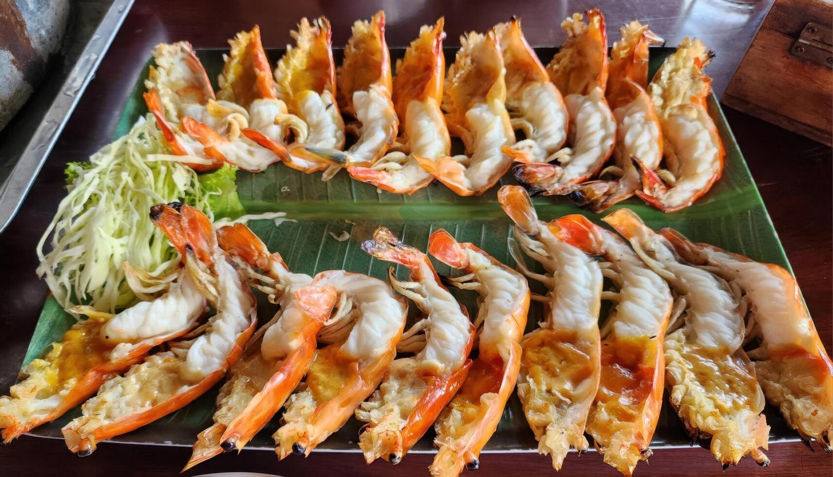 Grilled Shrimp Dish Served on Green Banana Leaf in Tropical Setting photo