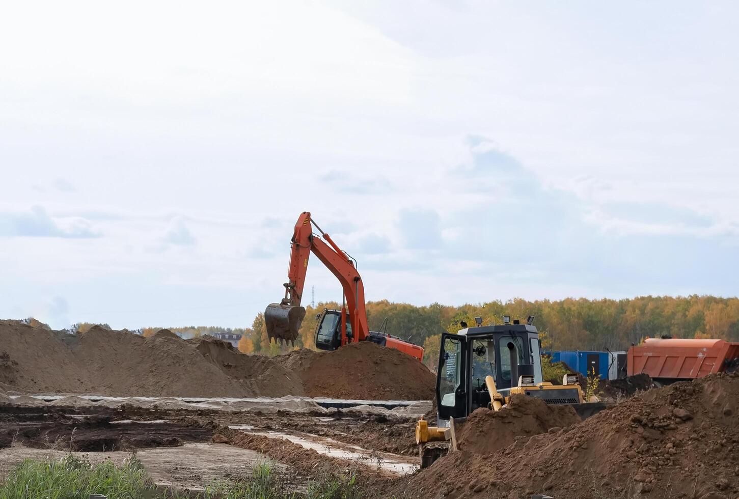 Excavator during earthmoving. Construction machinery and earth-moving heavy equipment for excavation, loading, lifting and hauling of cargo on job sites photo